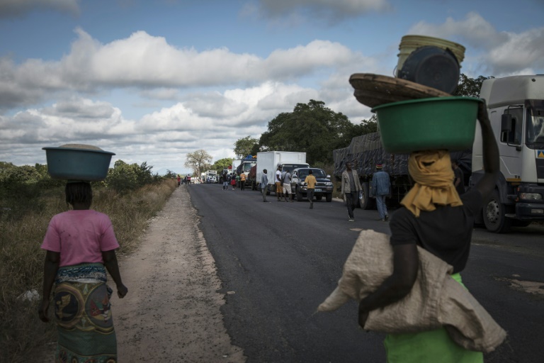 AFP/File / John Wessels<br />Street vendors sell to drivers along Mozambique's main north-south road as they wait for a military escort to provide protection for trucks and travellers