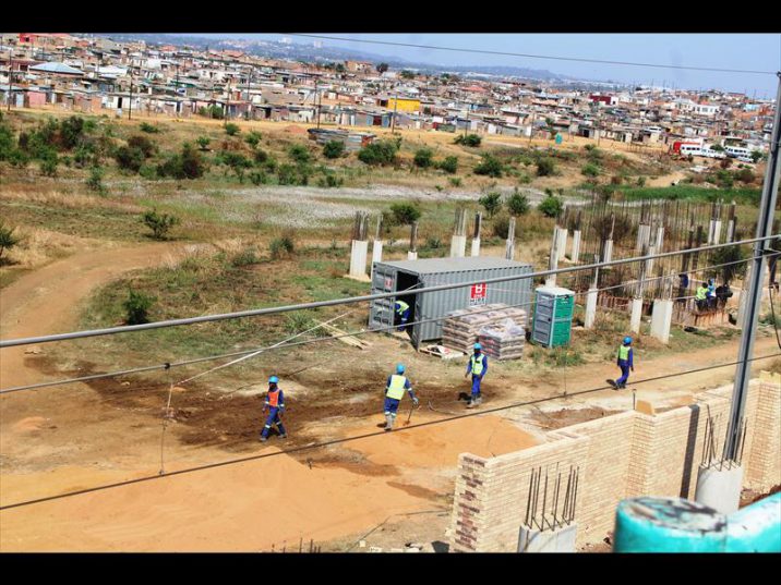 Prasa workers build a wall to prevent pedestrians crossing the railway tracks.