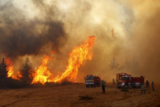 Picture released on March 12, 2017 by Aton Chile shows firefighters working to put out a forest fire in Valparaiso. Chilean authorities decreed red alert in Valparaiso and Vina del Mar for several forest fires. / AFP PHOTO / ATON CHILE / Raul ZAMORA / Chile OUT