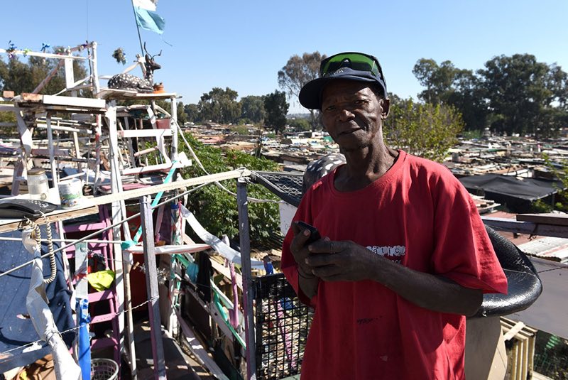 Johannes stands on the third floor of his home where you can take in a view of the surrounding informal settlement.