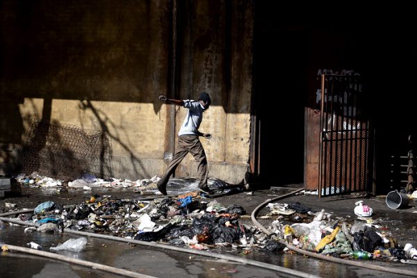 A man jumps over a dead body at the Cape York building on the corner of Nugget and and Jeppe street in Hillbrow that caught fire, 5 July 2017. One person died after jumping from the second floor of the building, while six others burnt to death or died from smoke inhalation according to the EMS on the scene. Some residents made ropes from sheets to get out, while some refused to leave the hijacked building. Picture: Tracy Lee Stark