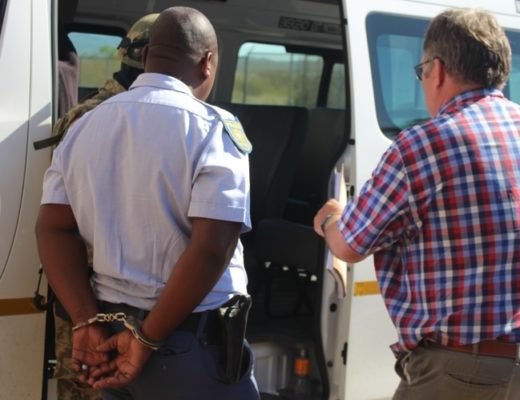 Cop charged with corruption are taken away