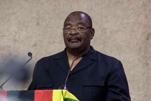 Zimbabwe's Secretary for Finance Obert Mpofu reads a statement to delegates during the ZANU PF (Zimbabwe African National Union - Patriotic Front) Central Committee meeting to recall Zimbabwe's president on November 19, 2017 at the party's headquarters in Harare. Zimbabwe's president must leave office on November 19, 2017, the head of Zimbabwe's war veterans association said as pressure builds on the authoritarian leader to resign after a military takeover. / AFP PHOTO / Jekesai NJIKIZANA