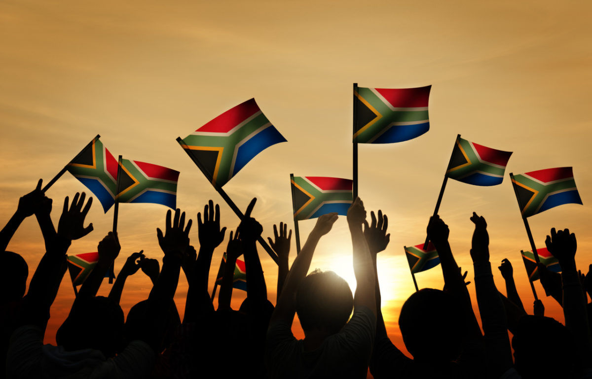 Group of People Waving South African Flags in Back Lit