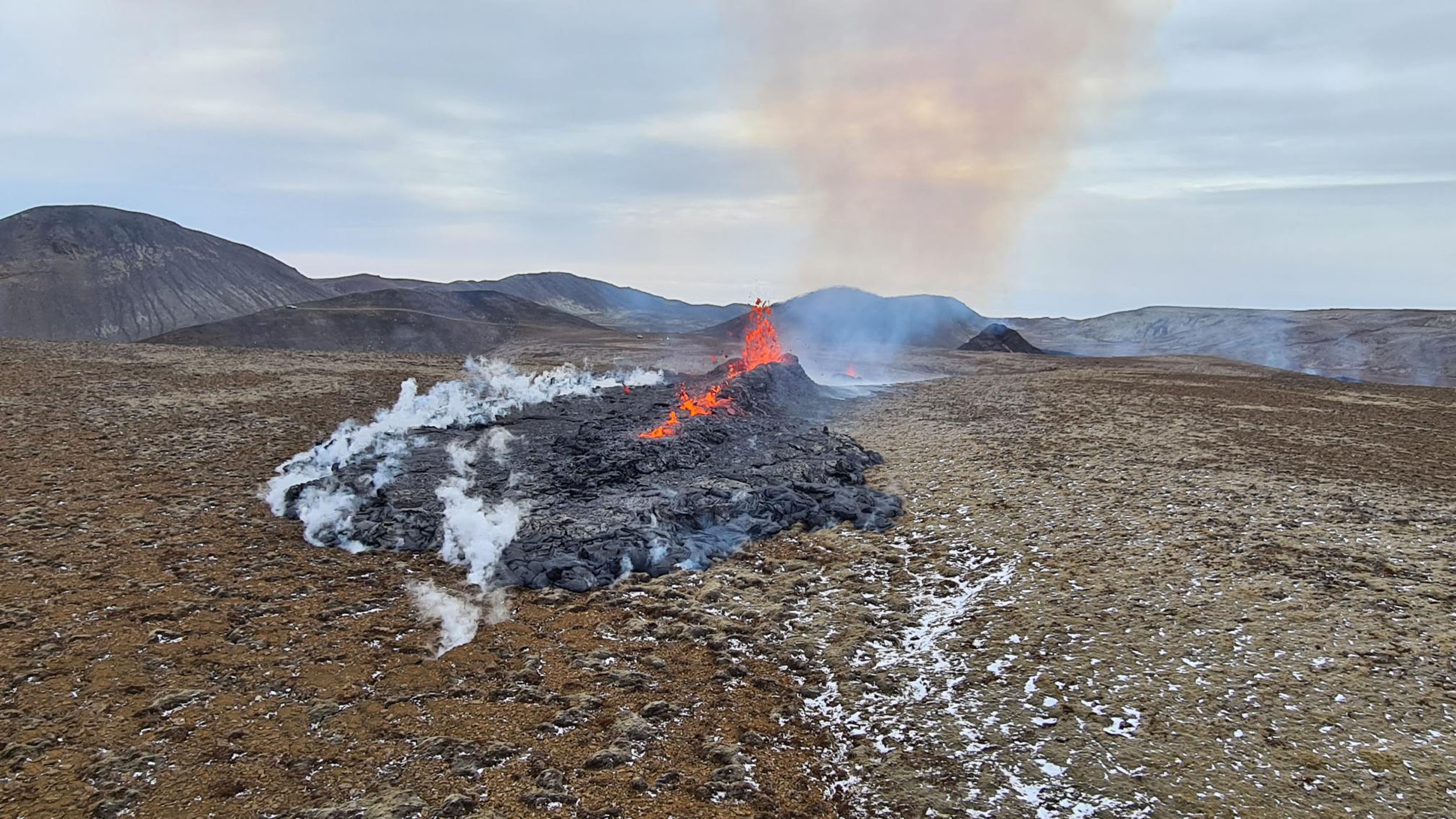 A handout picture released by the Icelandic Department of Civil Protection and Emergency Management shows lava flowing from a crack near Grindavik, on April 5, 2021. - The volcanic eruption, which has been ongoing for more than two weeks in Iceland about 40 kilometers from Reykjavik, spread on April 5, 2021 with a new fault spewing lava, according to the meteorological institute and live images from Icelandic television. (Photo by Handout / Icelandic Department of Civil Protection and Emergency Management / AFP) / RESTRICTED TO EDITORIAL USE - MANDATORY CREDIT "AFP PHOTO /ICELANDIC COAST GUARD " - NO MARKETING - NO ADVERTISING CAMPAIGNS - DISTRIBUTED AS A SERVICE TO CLIENTS