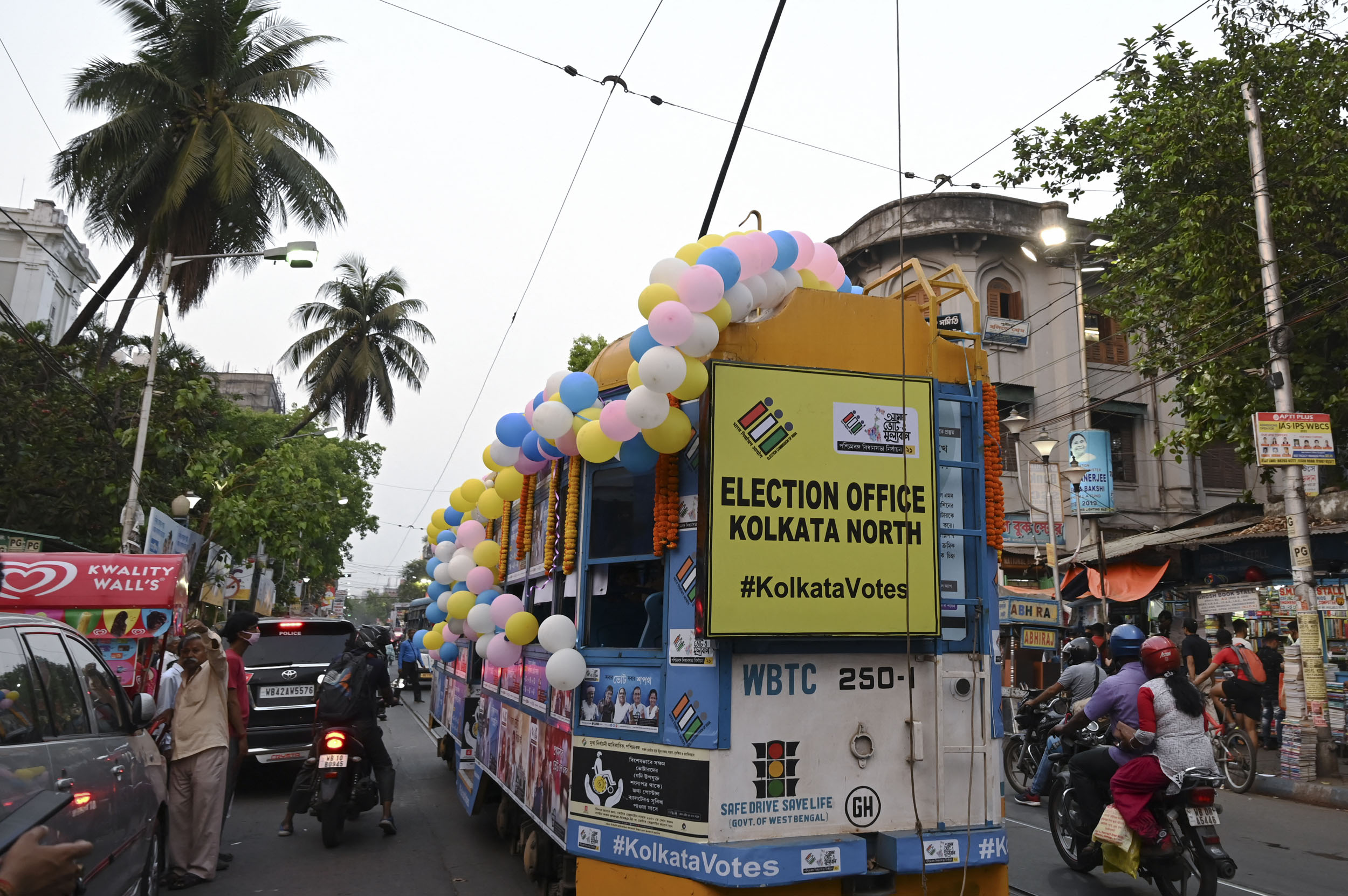 A tram decorated with posters of the ongoing state Legislative Assembly elections crosses a road in Kolkata on April 5, 2021. (Photo by Dibyangshu SARKAR / AFP)