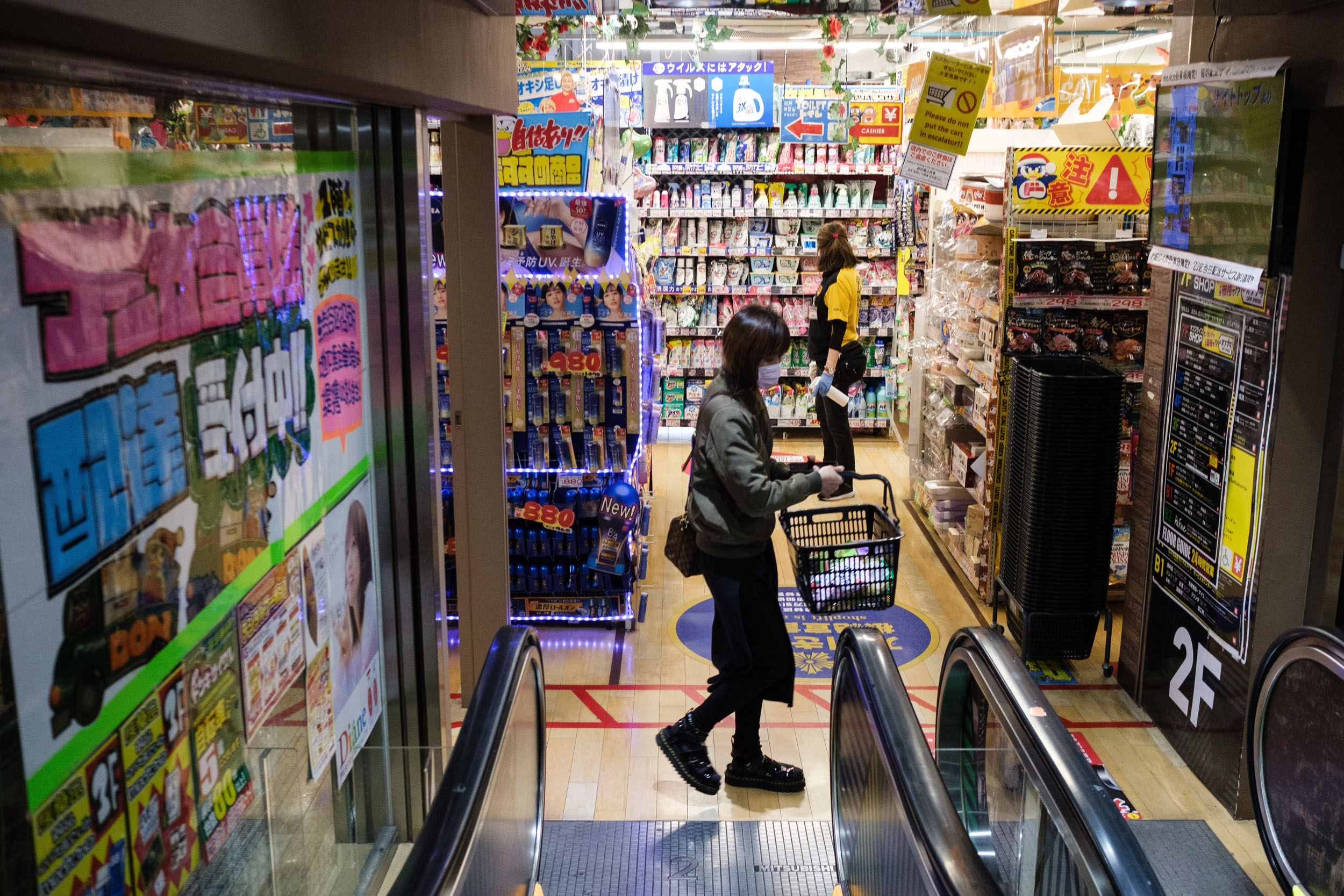 A woman shops at a supermarket in Shinjuku district of Tokyo on April 6, 2021. (Photo by Yuki IWAMURA / AFP)