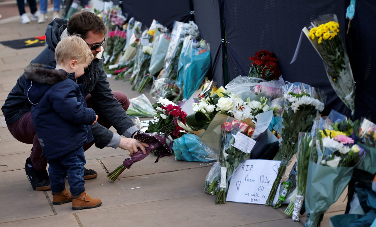 Well-wishers add flowers to the tributes outside Buckingham Palace in central London, on April 11, 2021, two days after the death of Britain's Prince Philip, Duke of Edinburgh, at the age of 99. - The funeral of Queen Elizabeth II's husband, Prince Philip, will take place next week, Buckingham Palace said on April 10 , announcing a stripped-back ceremony due to coronavirus restrictions. The Duke of Edinburgh died peacefully on April 9 just two months short of his 100th birthday, triggering eight days of national mourning. (Photo by Tolga Akmen / AFP)