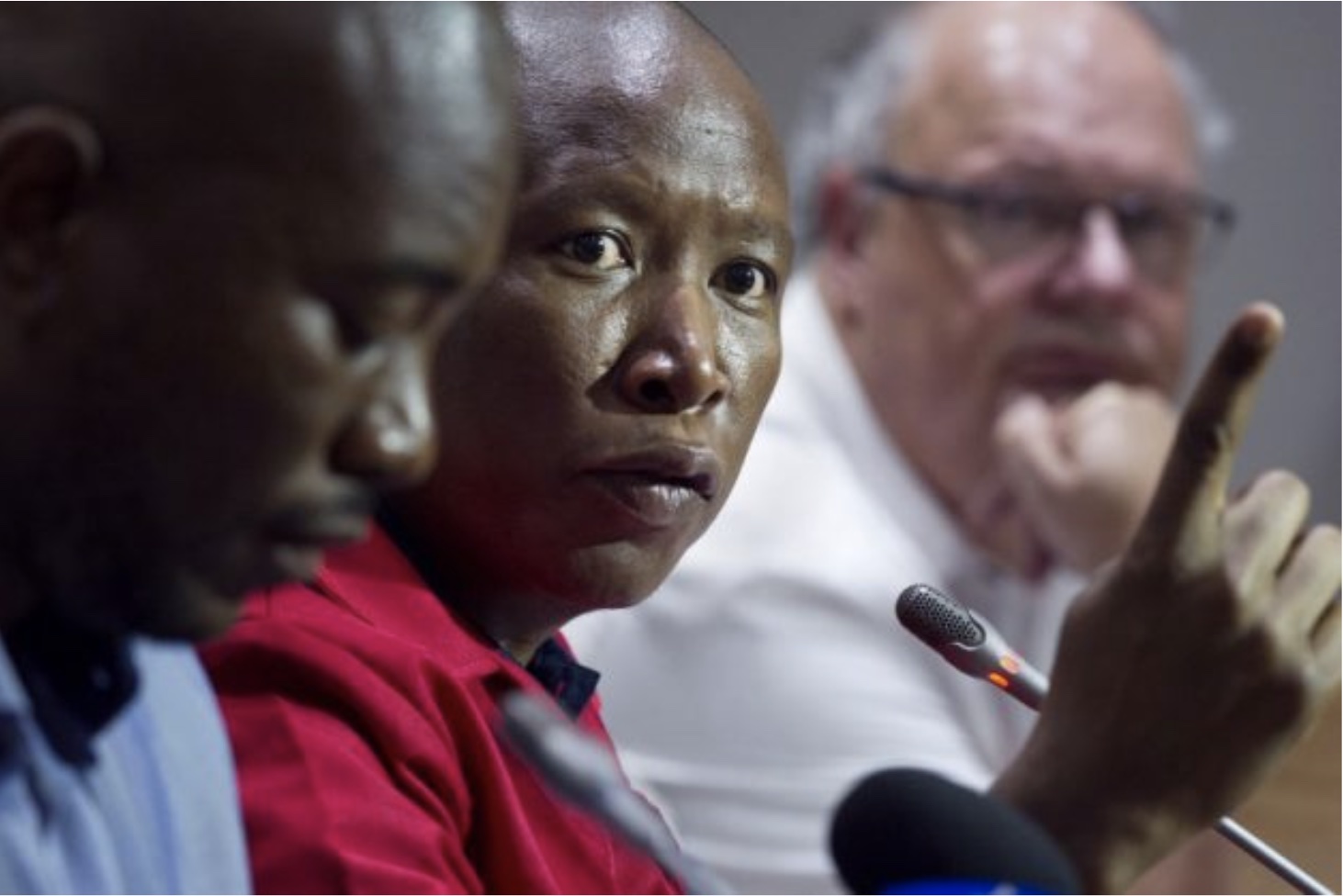 Economic Freedom Fighters (EFF) party leader Julius Malema (2nd L) speaks flanked by Democratic Alliance (DA) party leader Mmusi Maimane (L), and Corne Mulder (R) of the Freedom Front Plus (FF+), as they give a press conference. / AFP PHOTO / RODGER BOSCH