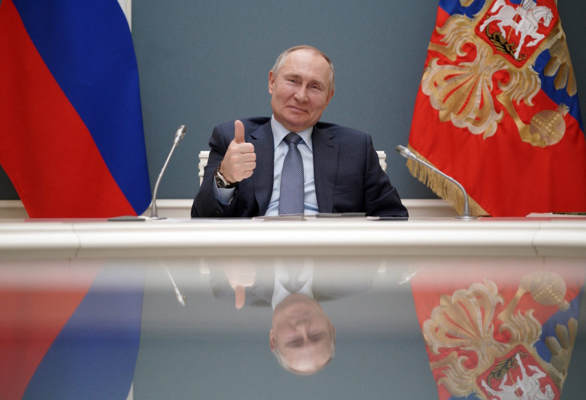 Putin sitting behind a table