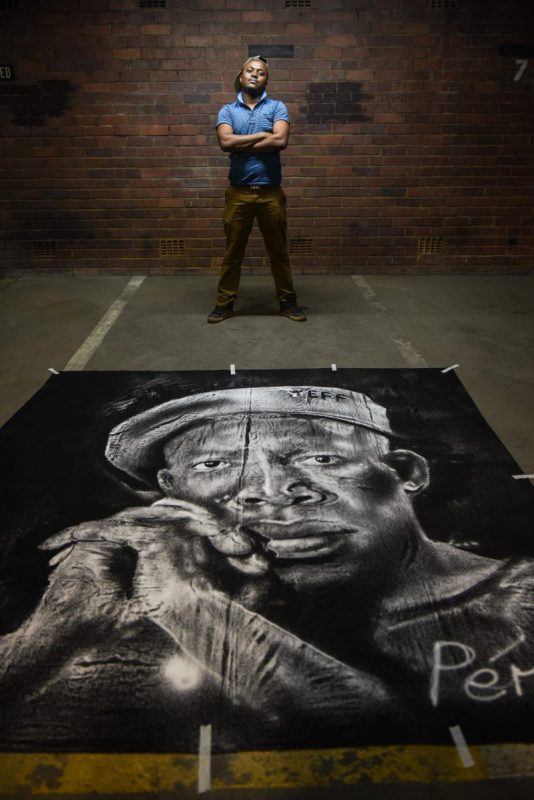 Percy Maimela poses for a picture alongside his portrait of Julius Malema made using only salt. Picture: Jacques Nelles