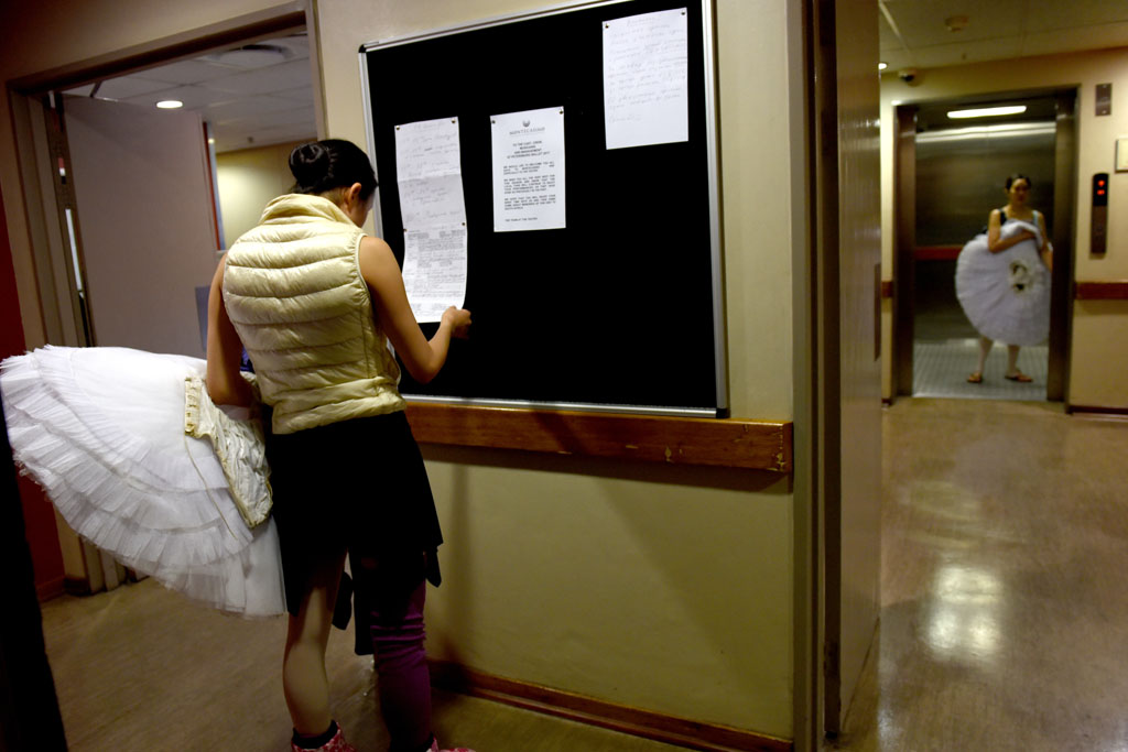 A ballet dancer reads the final call sheet back stage ahead of a dress rehearsal for Swan Lake. Picture: Tracy Lee Stark